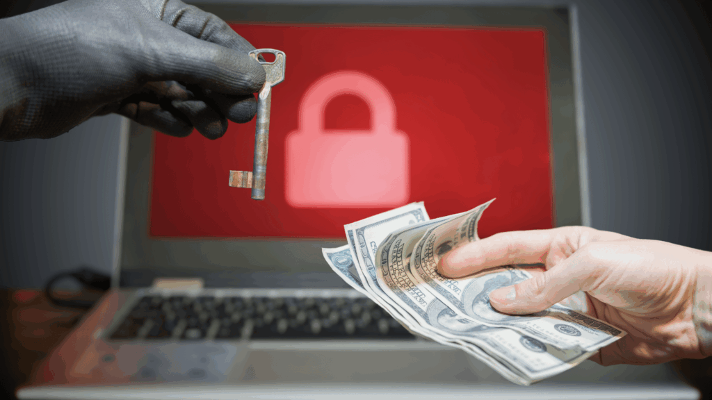 Hand mit Handschuh und Schlüssel andere Hand mit Geldscheinen und Laptop mit Schloss auf Bildschirm im Hintergrund als Symbol für Ransomware