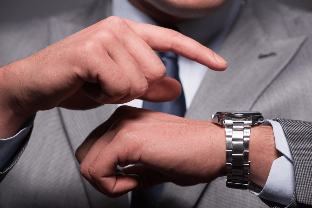 Mann zeigt auf Armbanduhr, denn schnelles Handeln ist kritisch, wenn ein Mobilgerät verloren geht.